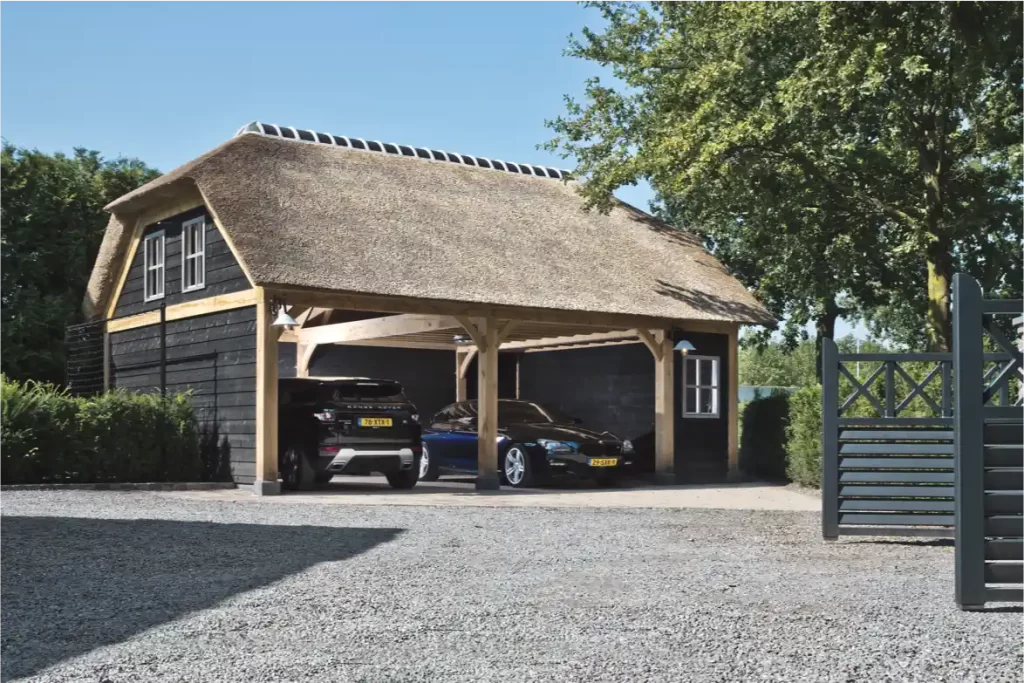 Eikenhouten carport bij een gebouw met rieten dak
