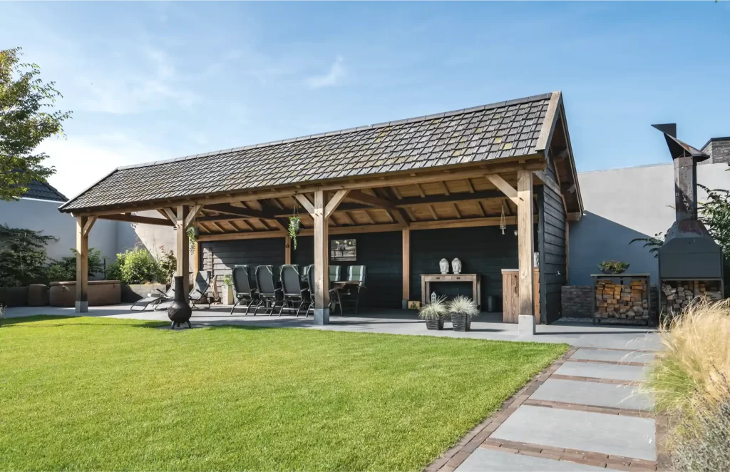 Buitenkeuken onder een eikenhouten veranda naast een tuin