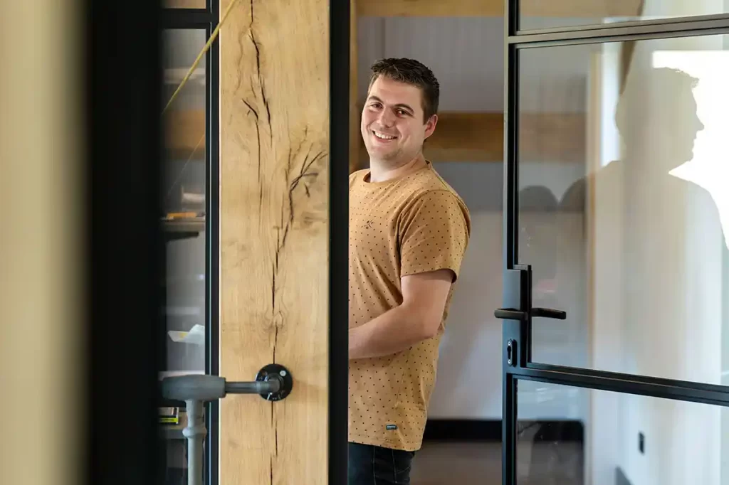 Man bij een open deur met eikenhouten frame