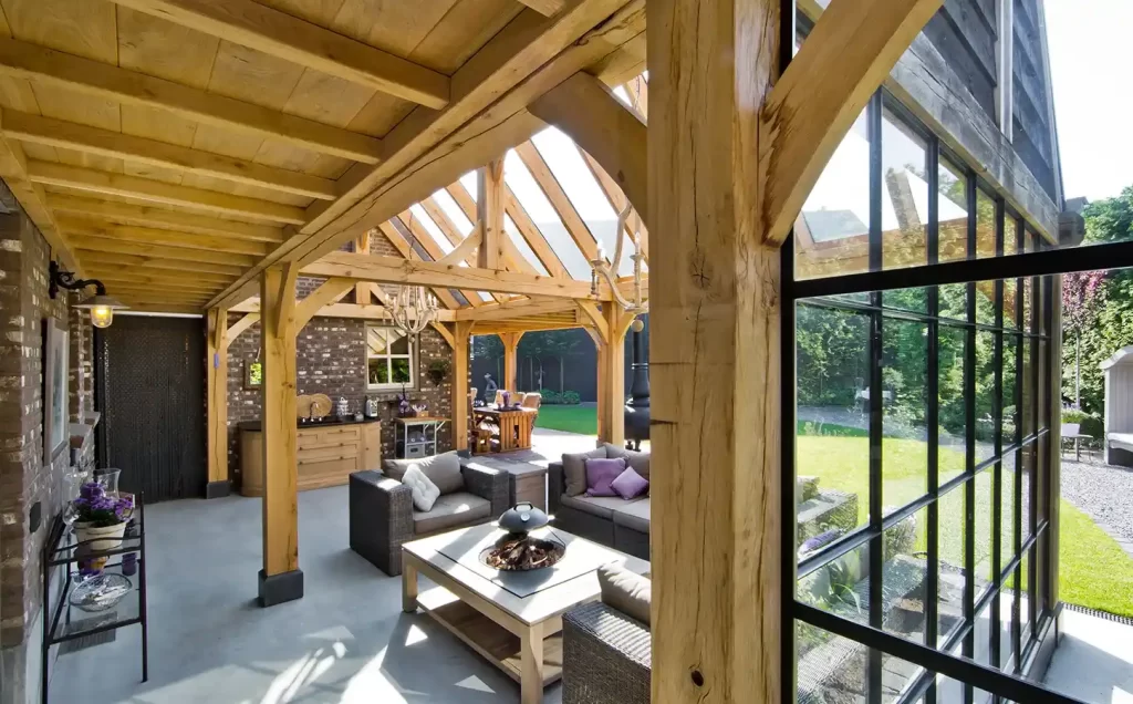 Glazen tuinkamer met eikenhouten staanders en loungemeubels
