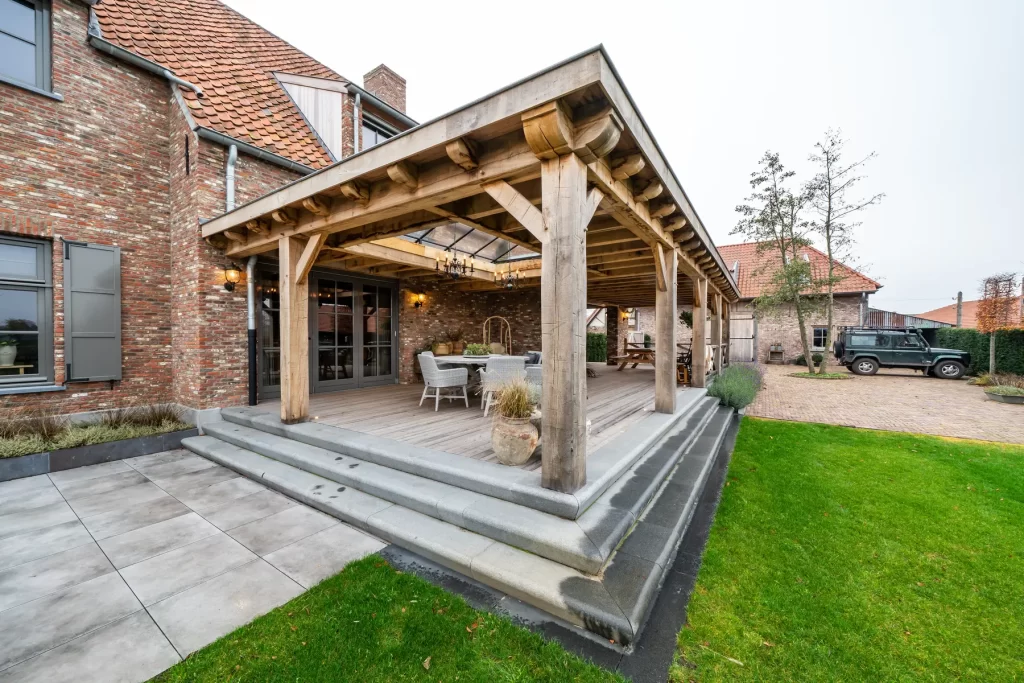 Eikenhouten overkapping met staanders, daklichten en traptreden aan de woning.